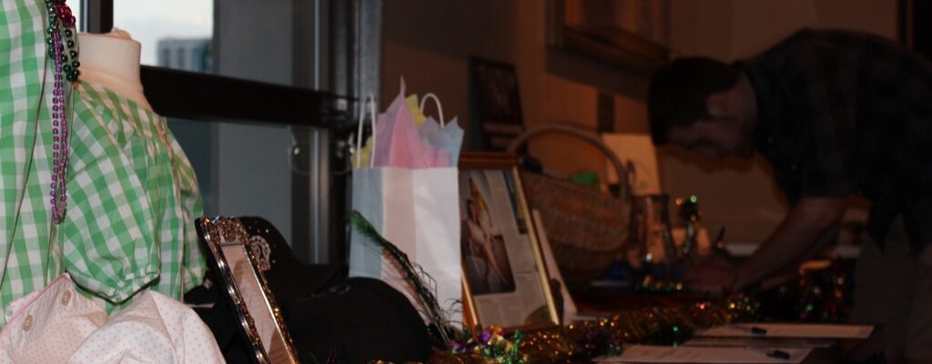 A table with various auction items including jewelry and framed photos.