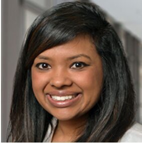 Smiling woman with long dark hair in a professional setting.