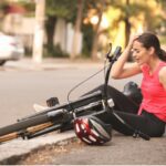 Woman sitting on the ground after a bike fall.
