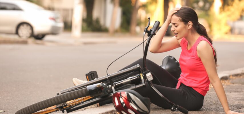 Woman sitting on the ground after a bike fall.