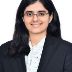 Professional woman in a dark blazer smiling.