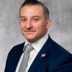 Professional man in a dark suit and tie.