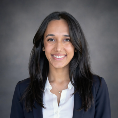 Professional woman smiling confidently in business attire.