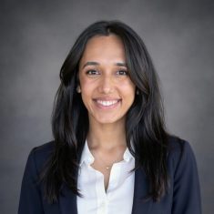 Professional woman smiling confidently in business attire.