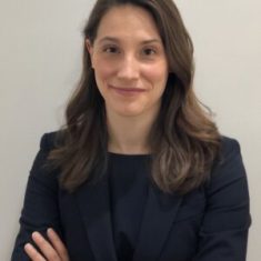 Professional woman in business attire smiling confidently.