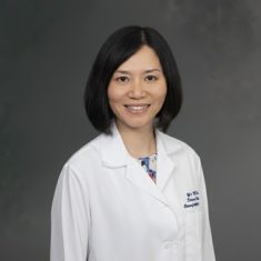 Professional portrait of a female medical doctor in a white coat.